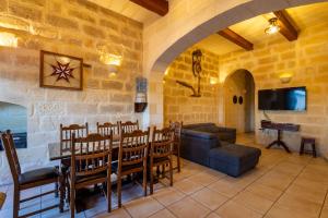 a living room with a table and chairs and a tv at Villayana Holiday Home in San Lawrenz
