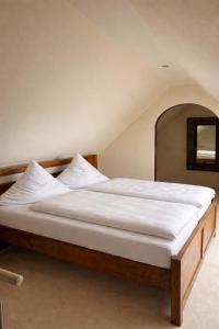 a bedroom with a large bed with white sheets at Vier Jahreszeiten Hotel in Husum +9 photos