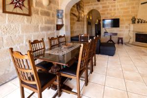 a dining room with a table and chairs and a fireplace at Villayana Holiday Home in San Lawrenz