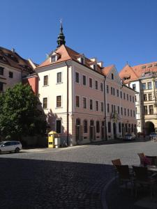 a large white building with chairs in a street at Hotel Börse in Görlitz