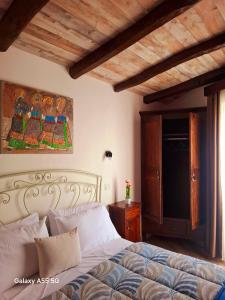 a bedroom with a bed and a painting on the wall at Biginau ' e giosso in Ilbono