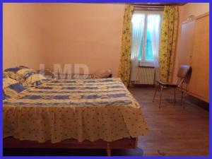 a bedroom with a bed with a quilt on it at Le Pakitoun in Boisse-Penchot