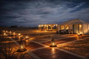 a large tent with lights in the desert at night at Hidden luxury Camp in Merzouga