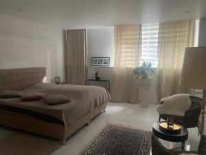 a bedroom with a large bed and a chair at Moderne, ruhige Ferienwohnung , ideal zum Abschalten in Hadamar