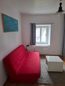 a red couch in a living room with a window at Escale cosy à Blois in Blois