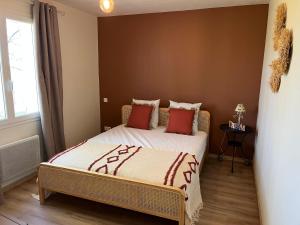a small bedroom with a bed with red pillows at Gîte de Combe Falce in Salignac Eyvigues +8 photos