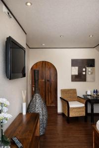 a living room with a couch and a tv at Vier Jahreszeiten Hotel in Husum
