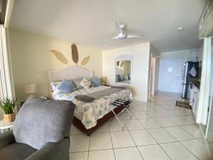 a bedroom with a bed and a couch at Oceanview large studio, pool, walk to Mullet Bay, Cupecoy Beach, walk to dining, free parking in Cupecoy