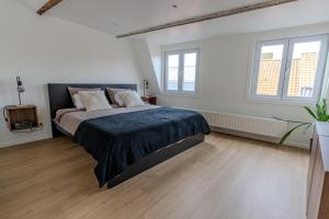 a bedroom with a large bed and two windows at BnB 26 in Blankenberge