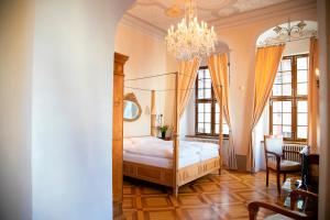 a bedroom with a canopy bed with a chandelier at Hotel Börse in Görlitz