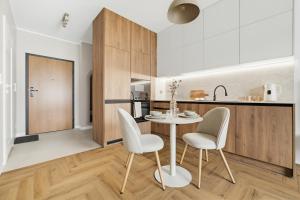a kitchen and dining room with a table and chairs at Neon Apartments Centrum in Częstochowa