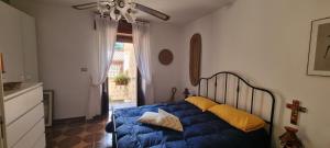 a bedroom with a blue bed with yellow pillows at Iris in Rodio