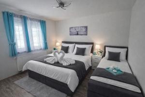 two beds in a room with blue curtains and blue windows at Plitvice Harmony one - seven person in Smoljanac