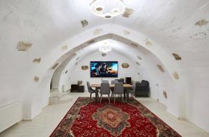 a dining room with a table and a tv on the wall at Green Garden Hotel in Baku