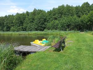 a boat sitting on a dock next to a bench at Olchowym Domek in Gostynin