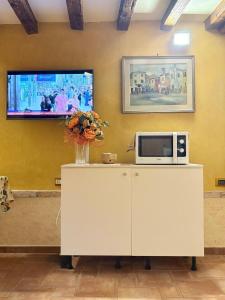 a microwave on a cabinet with a vase of flowers at Casa delle gondole in Venice