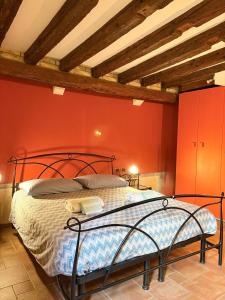 a bedroom with a bed in a red wall at Casa delle gondole in Venice