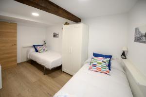 a small bedroom with two beds and a cabinet at Apartamentos California in Béjar