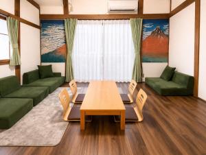 a living room with a table and green furniture at 75m2 10people private house rental 8beds 8min Ikebukuro 13min Shinjuku 18min Shibuya Englishspeaking staff available in Tokyo