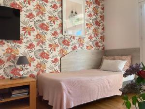 a bedroom with a bed with a flowery wallpaper at Pavillon de l’Étang in Châteauneuf-du-Rhône +43 photos