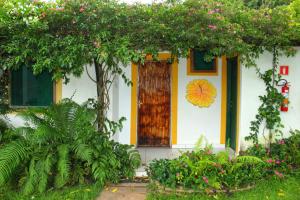 a house with a wooden door and flowers at Eco Charme da Bodoquena in Bodoquena