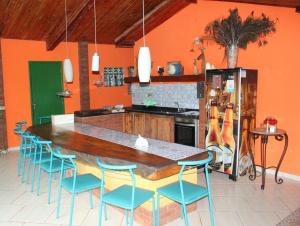 a kitchen with a large wooden table and blue chairs at Eco Charme da Bodoquena in Bodoquena