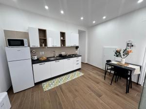 a kitchen with white cabinets and a table and a microwave at Holiday Home Tarinuzza in Lipari