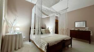 a bedroom with a canopy bed and a table at Susanna's House in Nocera Inferiore