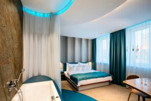 a hotel room with a bed and a bath tub at Pytloun Imperial Design Suites in Liberec