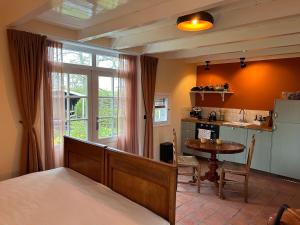 a bedroom with a bed and a table and a kitchen at Studio 1772 in Kamperland