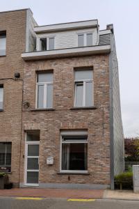 a brick building with white windows on a street at BnB 26 in Blankenberge
