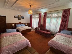 a hotel room with two beds and a chandelier at Pahuna Homestay in Kathmandu