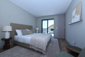 a bedroom with a large bed and a large window at Villa Macedo in Ponta do Sol +73 photos
