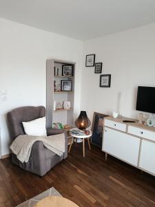 a living room with a couch and a tv at Petite maison dans le Morvan in Luzy