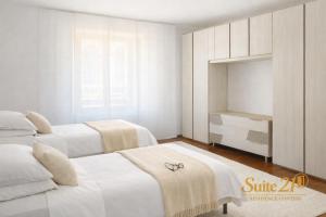 a white bedroom with two beds and a cabinet at Suite 21 - Residence Contini in Falconara Marittima