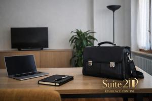a laptop computer sitting on top of a table with a bag at Suite 21 - Residence Contini in Falconara Marittima