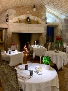 a restaurant with tables with white table cloths and a fireplace at Château Hôtel La Terrasse - Teritoria in Meyronne