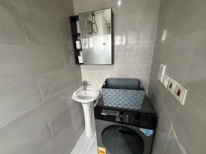 a small bathroom with a sink and a washing machine at 1 Pees Place in Christiansborg