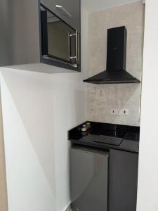 a small kitchen with a stove and a microwave at 1 Pees Place in Christiansborg