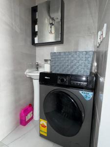 a washing machine in a bathroom with a sink at 1 Pees Place in Christiansborg
