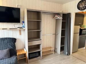 a room with a closet with a refrigerator and a tv at Le Cocon d'Aurouze in Le Dévoluy