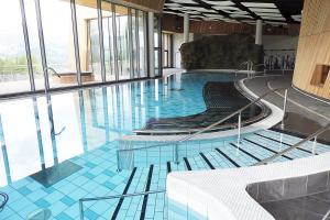 a large swimming pool with chairs and water in a building at Le Cocon d'Aurouze in Le Dévoluy