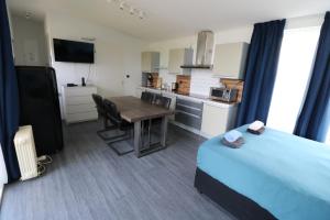 a bedroom with a bed and a table and a kitchen at Waegen Uus in Wolphaartsdijk