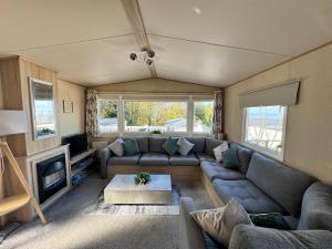 a living room with a couch and a tv at Kieras View At Bideford Bay in Bideford