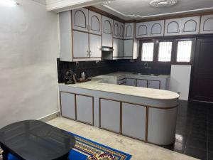 a kitchen with white cabinets and a counter top at Pahuna Homestay in Kathmandu +14 photos