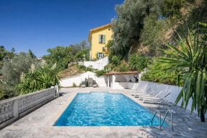 a swimming pool in front of a yellow house at House on the Hill in Nice