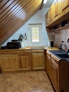 a kitchen with wooden cabinets and a sink and a window at Cabana Trofelor in Comandău