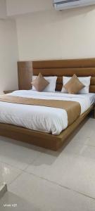 a large bed with a wooden frame in a room at HOTEL KONARK in in Vastral +18 photos