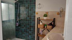 a bathroom with a green tiled shower with a sink at Dúplex en centro, San Ildefonso in Jaén +12 photos
