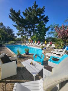 a group of chairs and a swimming pool at Le Manoir Lacustre in Queyrac